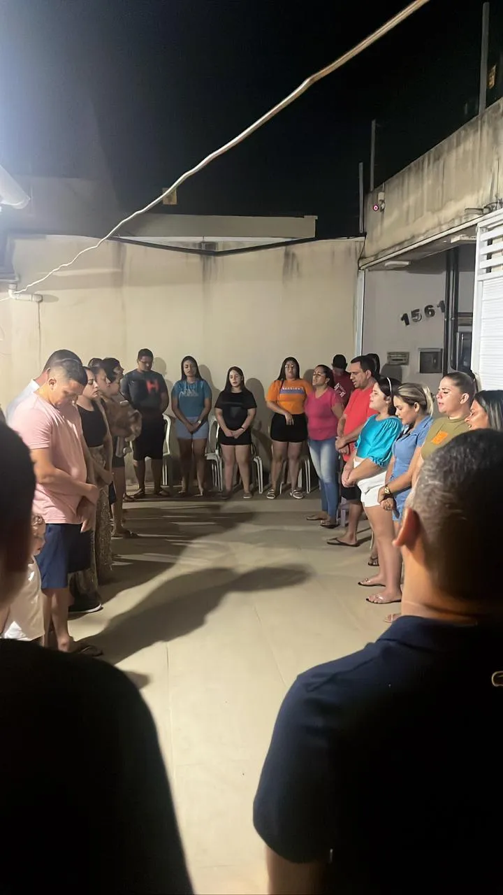 Irmãos em círculo de oração à noite